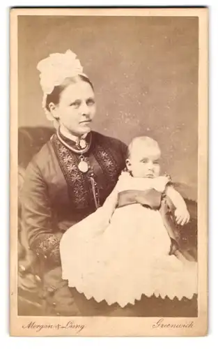 Fotografie Morgan & Laing, Greenwich, Portrait stolze Mutter mit niedlicher kleiner Tochter im Taufkleid
