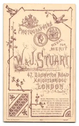 Fotografie W. & J. Stuart, London, 47, Brompton Road, Portrait niedliches Kleinkind im weissen Kleid auf Fell sitzend