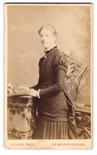 Fotografie W. & J. Stuart, London, 47, Brompton Road, Portrait bürgerliche Dame mit Buch an Sockel gelehnt