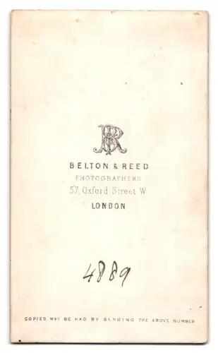 Fotografie Belton & Reed, London, 57 Oxford Street, Portrait junge Frau im weissen Kleid steht neben einem Stuhl