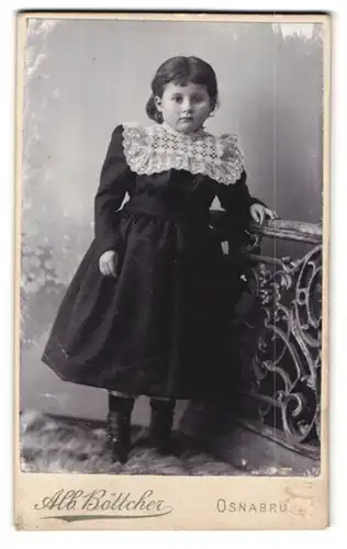 Fotografie Alb. Böttcher, Osnabrück, GeorgSTr. 1, Portrait kleines Mädchen im schwarzen Kleid mit Rüschenkragen