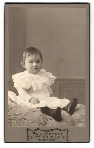 Fotografie Paul Oberst, Oelsnitz i. V., Bahnhofstr. Portrait Kleinkind im Kleidchen und Rüschenkragen