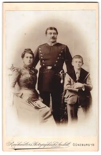 Fotografie Atelier Rauchmiller, Günzburg a. D., Offizier in Uniform mit Säbel nebst Frau & Sohn