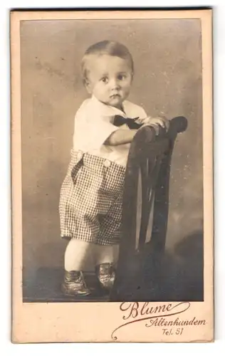 Fotografie Blume, Altenhundem, Portrait modisch gekleideter Junge auf Stuhl stehend