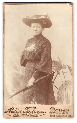 Fotografie Atelier Fortuna, Potsdam, Waisenstr. 58, Portrait elegant gekleidete Dame mit Hut und Schirm