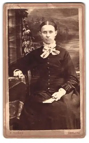 Fotografie E. Rohde, Berlin, Christinenstr. 30, Portrait elegant gekleidete Dame mit Buch in der Hand