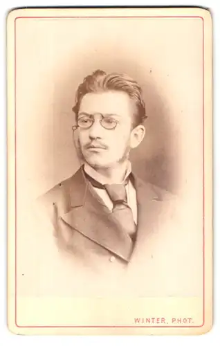 Fotografie M. L. Winter, Prag, Portrait stattlicher junger Mann in Zwicker und Anzug