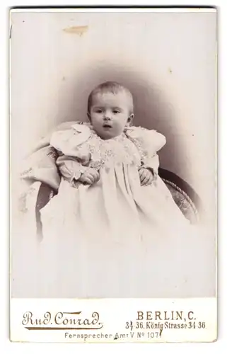 Fotografie Rud. Conrad, Berlin, Königstr. 34-36, Portrait niedliches kleines Mädchen im bestickten Kleidchen