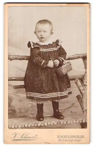 Fotografie J. Schmidt, Finsterwalde, Berlinerstr., Portrait süsses kleines Mädchen im Kleid mit Körbchen am Handgelenk