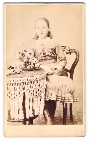 Fotografie W. Mack, Coleraine, New Row, Portrait junges Mädchen im Kleid am Tisch sitzend
