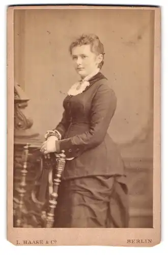 Fotografie L. Haase & Co., Berlin, Unter den Linden Nr. 62-63, Schöne Frau im Kleid mit Händen auf Rückenlehne