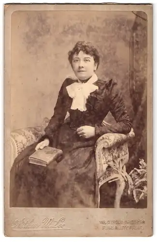 Fotografie Arthur W. Lee, London, 118 Stroud Green Road, Portrait Frau im schwarzen Kleid mit weisser Schleife