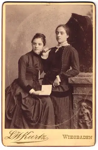 Fotografie L.W. Kurtz, Wiesbaden, Friedrichstr. 4, Portrait hübsche Frauen in langen Kleidern mit Buch und Schirm