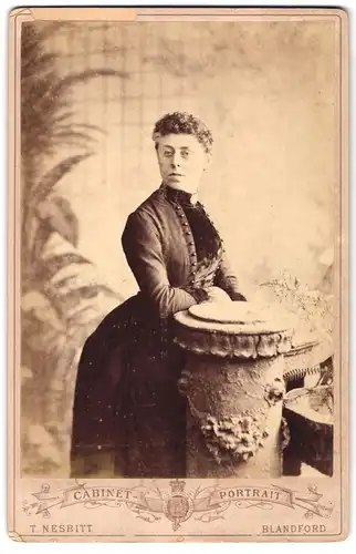 Fotografie T. Nesbitt, Blandford, Market Place, Portrait Frau mit modischer Frisur im Reifkleid