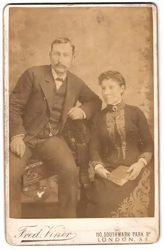 Fotografie Fred. Viner, London, 110, Southwark Park Road, Portrait junges Paar in modischer Kleidung mit Buch