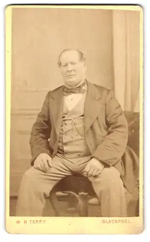 Fotografie W. H. Terry, Blackpool, South Pier, Älterer Mann im Anzug mit Schleife