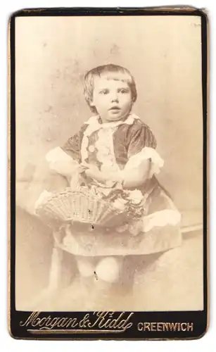 Fotografie Moorgan & Kidd, Greenwich, Junges Kind in Sonntagskleidung mit Korb voller Blumen