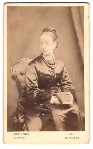Fotografie Fred James, London, 226. Oxford Street, Dame im Kleid mit Halskette und Buch
