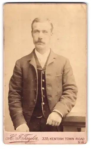 Fotografie H. J. Taylor, London, 335, Kentish Town Road, Portrait modisch gekleideter Herr an Geländer gelehnt