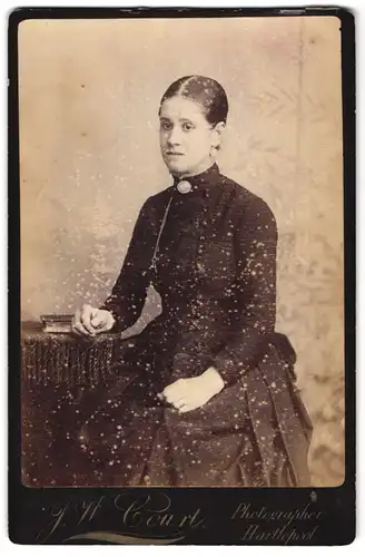 Fotografie J. W. Court, Hartlepool, Dame in schwarzem Kleid mit Brosche