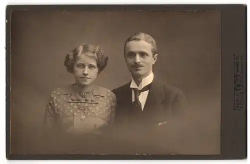Fotografie Adolf Stolle, Hamburg, Speersort 5, Junges Paar in Sonntagskleidung mit Lächeln