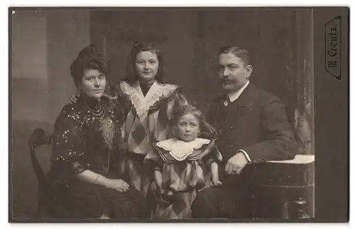 Fotografie M. Greutz, Hamburg, Altonaerstr. 2, Familienfoto in Ausgeh-Kleidung am Beistelltisch