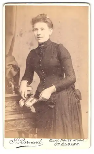 Fotografie J. Barnard, St. Albans, junge hübsche Dame mit Fotografien in Hand