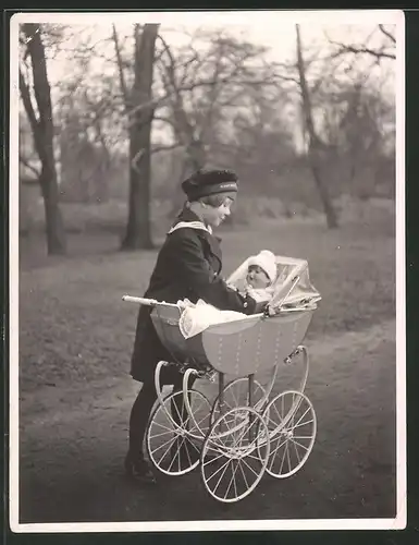 Fotografie Mädchen in Marineuniform mit Puppe und Puppenwagen