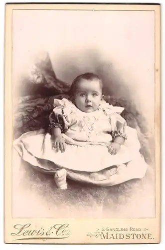 Fotografie Lewis & Co., Maidstone, 6, Sandling Road, Portrait niedliches Kleinkind im Kleid auf Fell sitzend