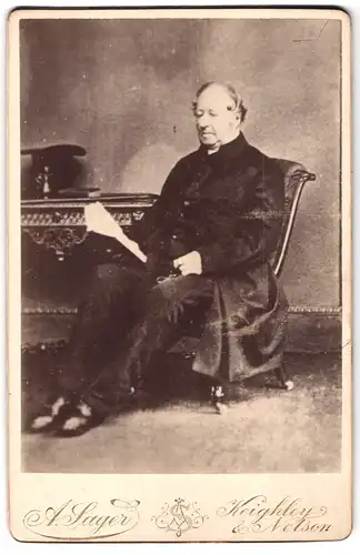 Fotografie A. Sager, Keighley & Nelson, Portrait bürgerlicher Herr mit Buch auf Stuhl sitzend