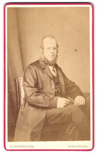 Fotografie E. Goodfellow, Wincanton, Portrait modisch gekleideter Herr am Tisch sitzend