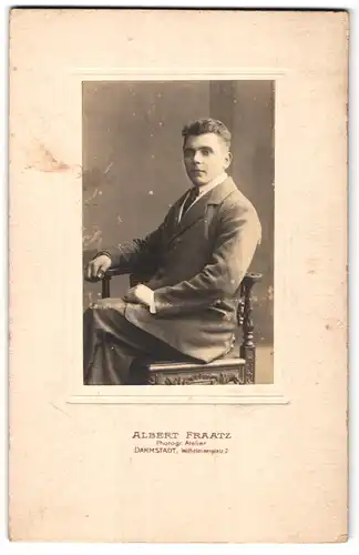 Fotografie Albert Fraatz, Darmstadt, Wilhelminenplatz 2, Portrait junger Herr im Anzug am Tisch sitzend