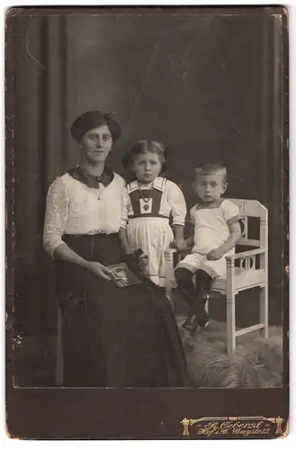 Fotografie R. Oeberst, Hof i. B., Bergstrasse 23, Portrait bürgerliche Dame mit Foto und zwei Kindern
