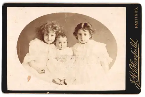 Fotografie J. H. Blomfield, Hastings, Portrait zwei kleine Mädchen und Klelinkind in weissen Kleidern