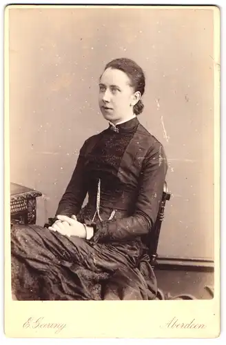 Fotografie E. Geering, Aberdeeen, 10 Union Place, Portrait junge Dame im Kleid auf Stuhl sitzend