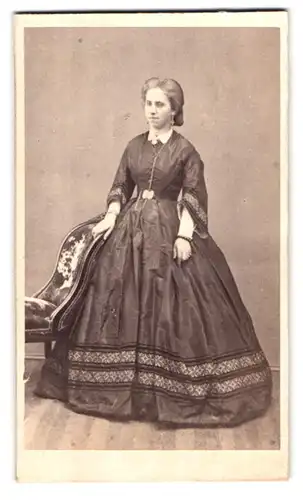 Fotografie unbekannter Fotograf und Ort, Frau mit zurückgesteckten Haaren und Ohrringen in schwarzem Kleid