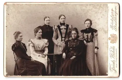 Fotografie Friedr. Wehde, Bückeburg, Portrait sechs Damen in zeitgenössischen Kleidern am Tisch