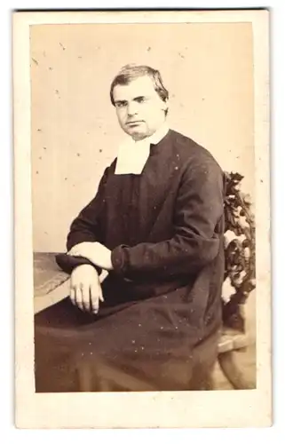 Fotografie unbekannter Fotograf und Ort, Portrait Geistlicher am Tisch sitzend