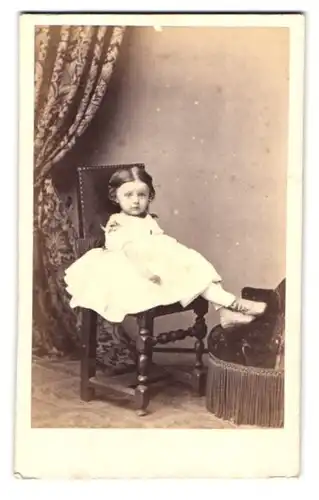 Fotografie J. Martin, Lyon, Rue de Bourbon 35, Kleines Mädchen in weissem Kleid sitzt und hat die Füsse auf Hocker