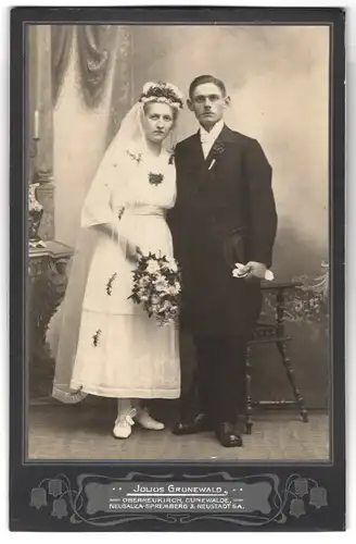 Fotografie Julius Grunewald, Oberneukirch, Portrait junges Paar in Hochzeitskleidung mit Schleier und Blumenstrauss