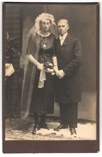 Fotografie Ateleir Rotstein, Reichenbach /O.-L., Portrait junges Paar in Hochzeitskleidung mit Schleier und Blumenstrauss