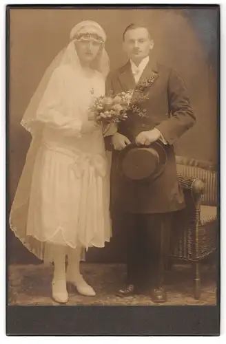 Fotografie unbekannter Fotograf und Ort, Portrait junges Paar in Hochzeitskleidung mit Schleier und Blumenstrauss