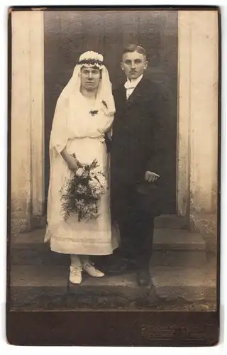 Fotografie Hermann Schöne, Oberlichtenau, Portrait junges Paar in Hochzeitskleidung mit Schleier und Blumenstrauss