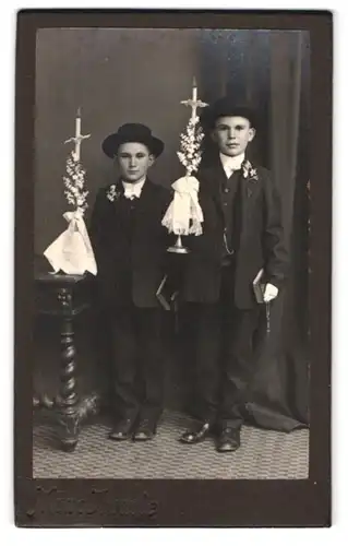 Fotografie unbekannter Fotograf und Ort, Portrait zwei freche Buben mit Kerzen in eleganten Anzügen zur Kommunion
