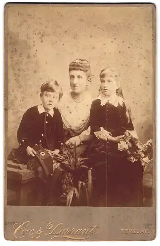 Fotografie Cox & Durrant, Torquay, Portrait junge Dame mit zwei Kindern in hübscher Kleidung