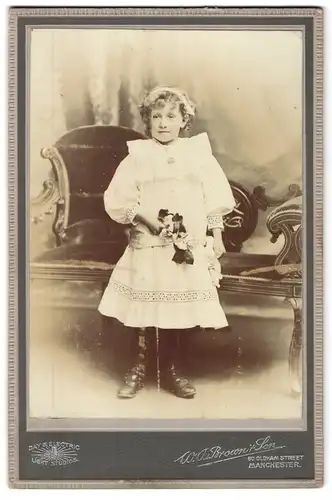 Fotografie W. A. Brown & Son, Manchester, 60, Oldham St., Portrait kleines Mädchen im weissen Kleid mit Blumen