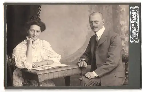 Fotografie Hermann Böbers, Berlin-Rixdorf, Saale Strasse 1, Portrait bürgerliches Paar mit Buch am Tisch