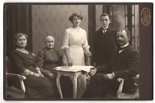 Fotografie Hermann Luh, Seifhennersdorf i /S., Portrait bürgerliche Familie in hübscher Kleidung am Tisch