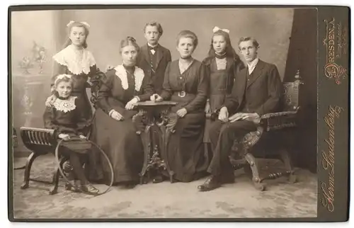 Fotografie Herm. Lindenberg, Dresden-A, Bürgerwiese 6, Portrait bürgerliche Familie in hübscher Kleidung am Tisch