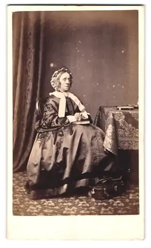 Fotografie A. & E. Seeley, London, Portrait ältere Dame in hübscher Kleidung mit Haube